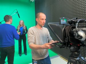 Hoosier Energy video producers Chris Johnson and Ben Turner instruct UDWI's Miranda Hostetter while shooting a capital credits video in the studio at Hoosier headquarters.
